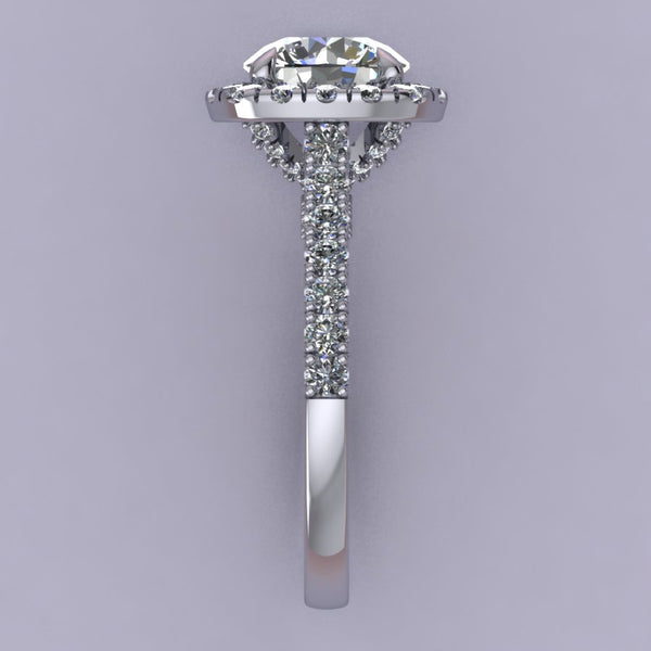 This rendering features a round brilliant center stone set in a soft cushion halo with a diamond basket, diamond bridge, and an elegant cathedral style shank. The diamonds are set in a delicate but durable micro-prong setting style to maximize the brilliance of the diamonds. The height of the halo is medium to high, which helps create the look for more prominence and brilliance, showcasing the center stone best. 