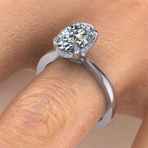 Hidden Halo with Tapered Shank Featuring Oval Brilliant This ring features an oval brilliant center stone set in a tapered pinched solitaire shank with a diamond basket that elegantly cradles the center stone.