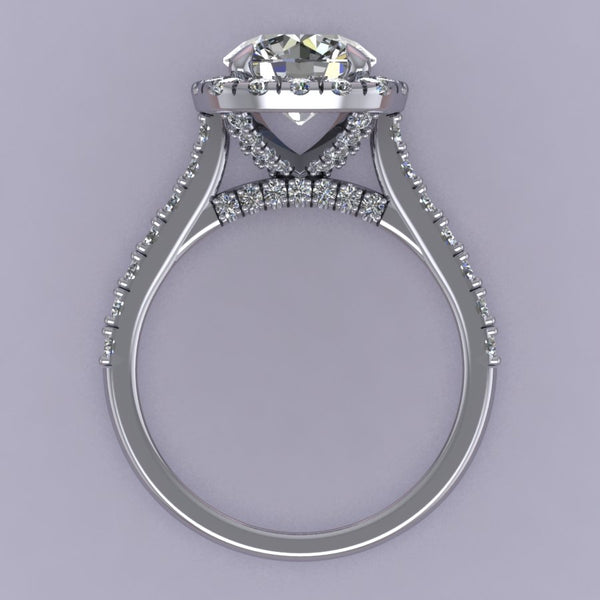 This rendering features a round brilliant center stone set in a soft cushion halo with a diamond basket, diamond bridge, and an elegant cathedral style shank. The diamonds are set in a delicate but durable micro-prong setting style to maximize the brilliance of the diamonds. The height of the halo is medium to high, which helps create the look for more prominence and brilliance, showcasing the center stone best. 